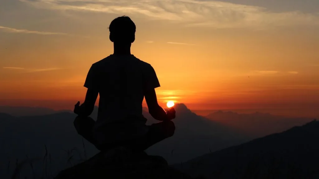 hombre meditando al amanecer